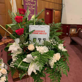 Standing floral tribute with red and white flowers on a metal easel