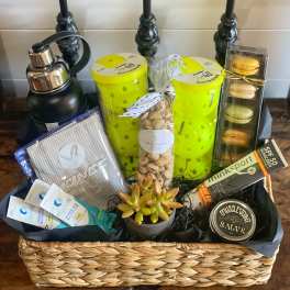Gift basket with water bottle, snacks, macaron box, and a small succulent