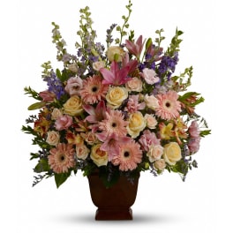 Mixed pink and cream flowers arranged in a brown vase