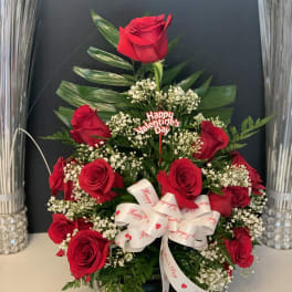 Red roses arranged with baby's breath and a Valentine ribbon