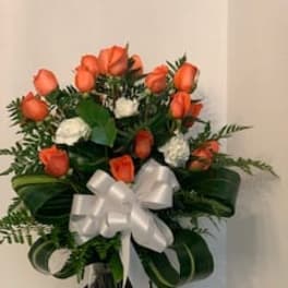 Orange rose bouquet with white flowers and a white ribbon