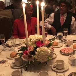 Candlelit table centerpiece with white and pink flowers at a formal dinner