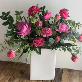 Pink flowers arranged in a white rectangular vase