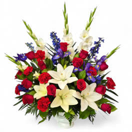 Mixed bouquet of red roses, white lilies, and blue flowers in a white vase