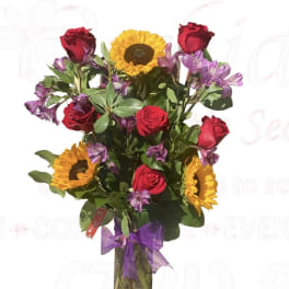 Bouquet of red roses and sunflowers in a glass vase with a purple ribbon