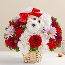 Flower arrangement shaped like a teddy bear in a wicker basket with a red bow