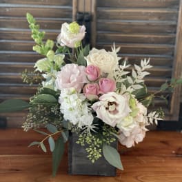 Pink and white floral arrangement in a black wooden box