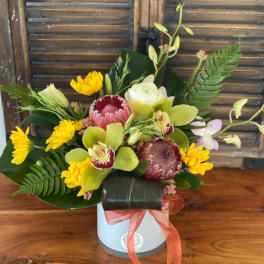Mixed tropical bouquet in a white box with a coral ribbon