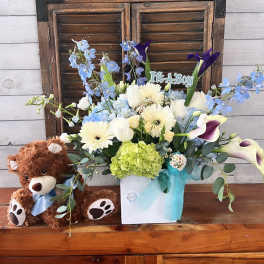 Bouquet in a white box with a teddy bear and blue ribbon