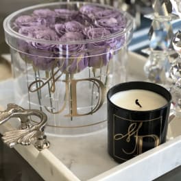 Lavender roses in a clear round box with a black candle and crystal decor