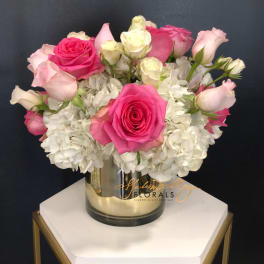 Pink and white roses arranged in a glass vase