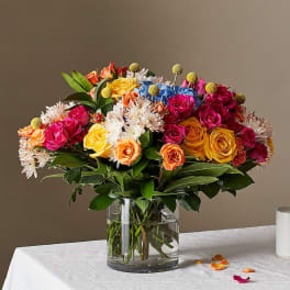 Mixed bouquet of roses and small white flowers in a glass vase