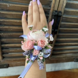 Pink rose wrist corsage with lavender ribbon and small purple flowers