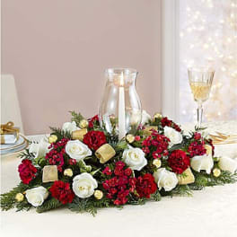 Low centerpiece of red and white roses with a glass candle holder