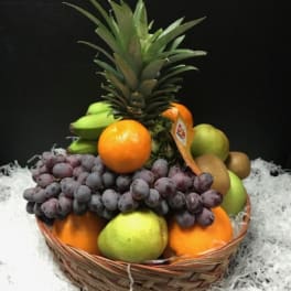 Fruit basket with pineapple, grapes, oranges, bananas, and pears