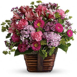 Pink mixed flower arrangement in a woven basket