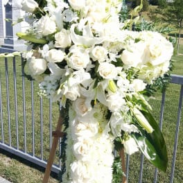 Large white funeral spray on an easel outdoors