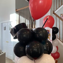 Cluster of red, black, white, and playing-card balloons on a table