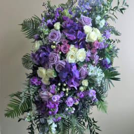 Large purple and white floral standing spray on an easel