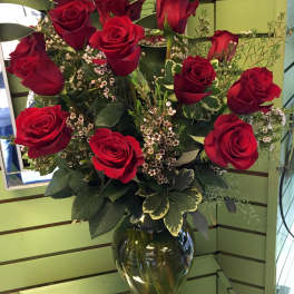 Red roses arranged in a clear glass vase