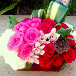 Bouquet of pink and red roses with white orchids and a lotus pod