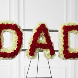 Floral tribute spelling DAD in red and white flowers on an easel