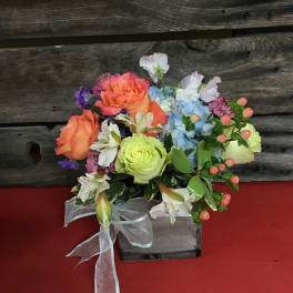 Colorful mixed bouquet in a rustic wooden box with a sheer ribbon