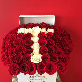 Heart-shaped box of red and white roses against a red background