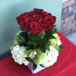 Red roses with white hydrangeas in a white square vase