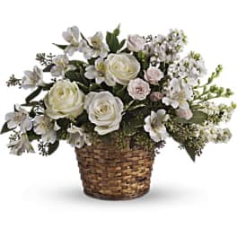 White roses and small white flowers in a woven basket