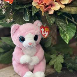 Pink plush cat beside an orange floral arrangement