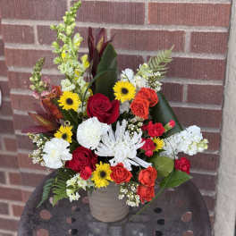Mixed bouquet in a beige vase with red, white, and yellow flowers