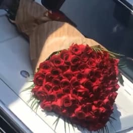 Large bouquet of red roses wrapped in brown paper