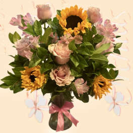 Bouquet of pink roses and sunflowers in a glass vase with a pink ribbon