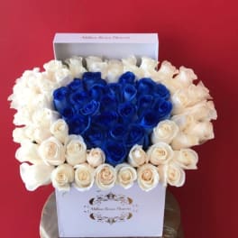 Heart-shaped bouquet of blue and white roses in a white box