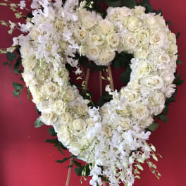 Heart-shaped white floral wreath on an easel