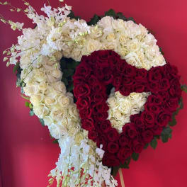 Heart-shaped floral tribute of red and white roses on an easel