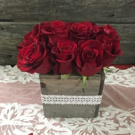 Red roses arranged in a rustic wooden box with lace trim