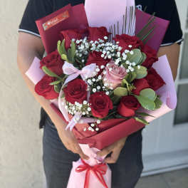 Bouquet of red and pink roses with baby's breath in pink wrapping