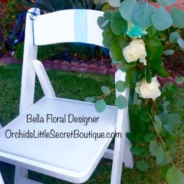 White chair decorated with eucalyptus and white roses