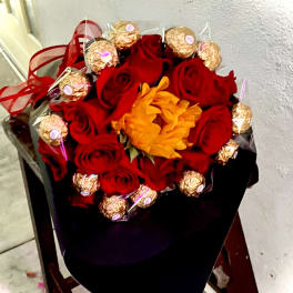Bouquet of red roses with gold-wrapped chocolates and an orange flower