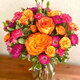 Bouquet of orange and pink flowers in a glass vase