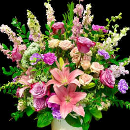 Pink and lavender floral arrangement in a white vase
