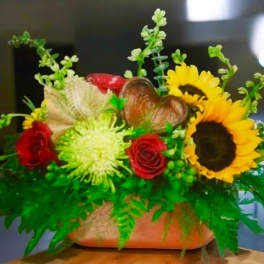 Mixed bouquet with sunflowers, red roses, and a heart decoration in a vase