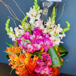 Bright mixed bouquet with pink, orange, and white flowers and a ribbon wrap