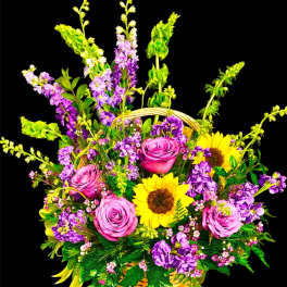 Basket arrangement with pink roses, sunflowers, and purple flowers