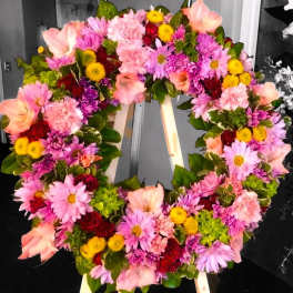 Heart-shaped floral wreath with pink, purple, yellow, and red blooms