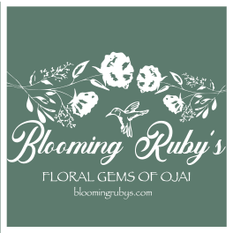 Blooming Ruby's floral shop logo on a green background with white flowers and a hummingbird