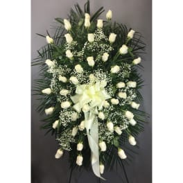 White rose standing spray with baby's breath and a pale ribbon