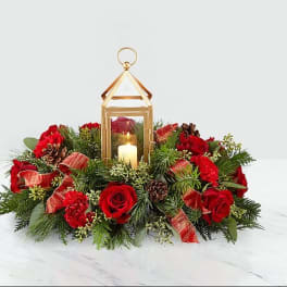 Red rose centerpiece with a gold lantern and candle
